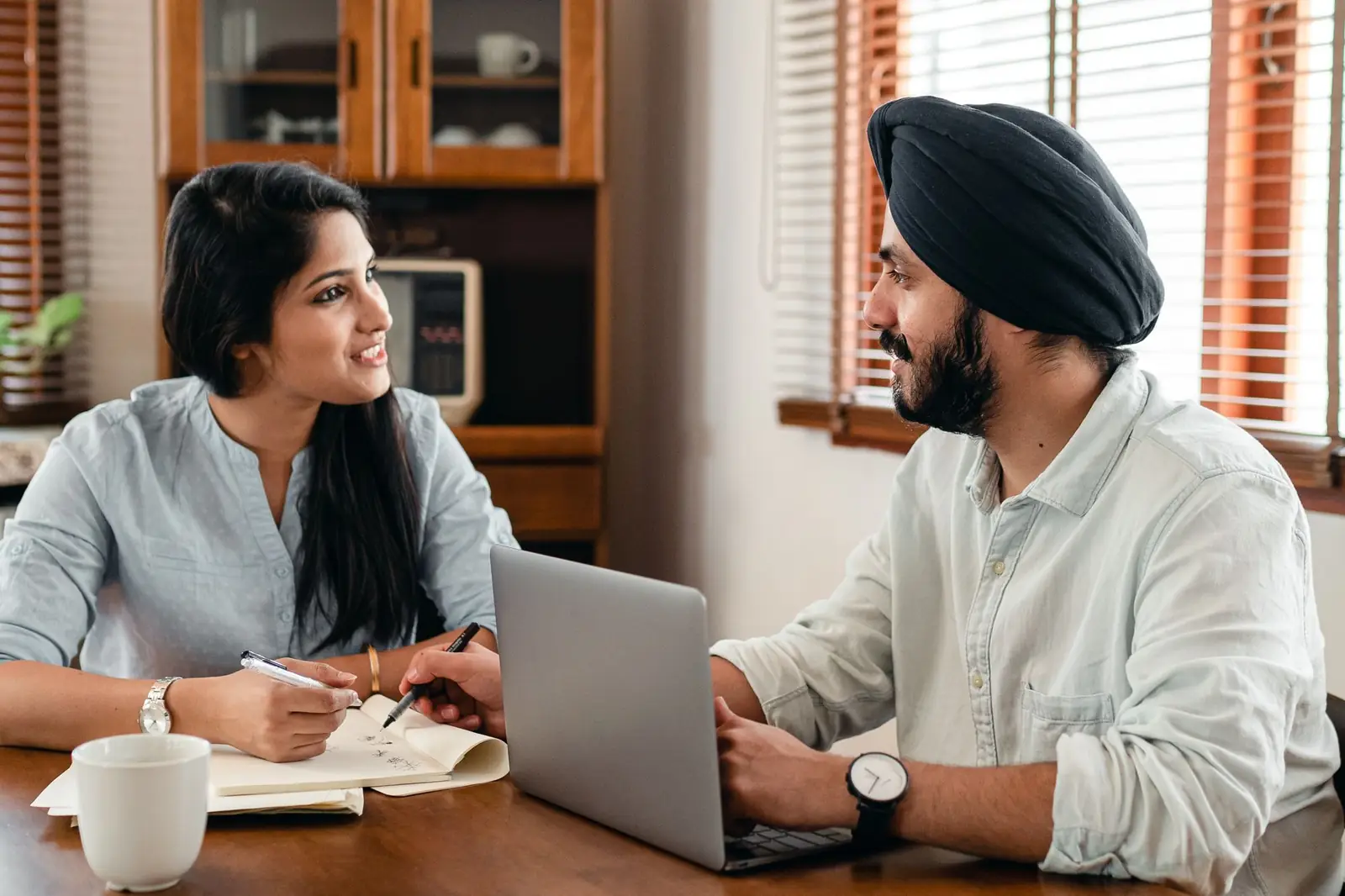 Two colleagues discussing a project over a laptop